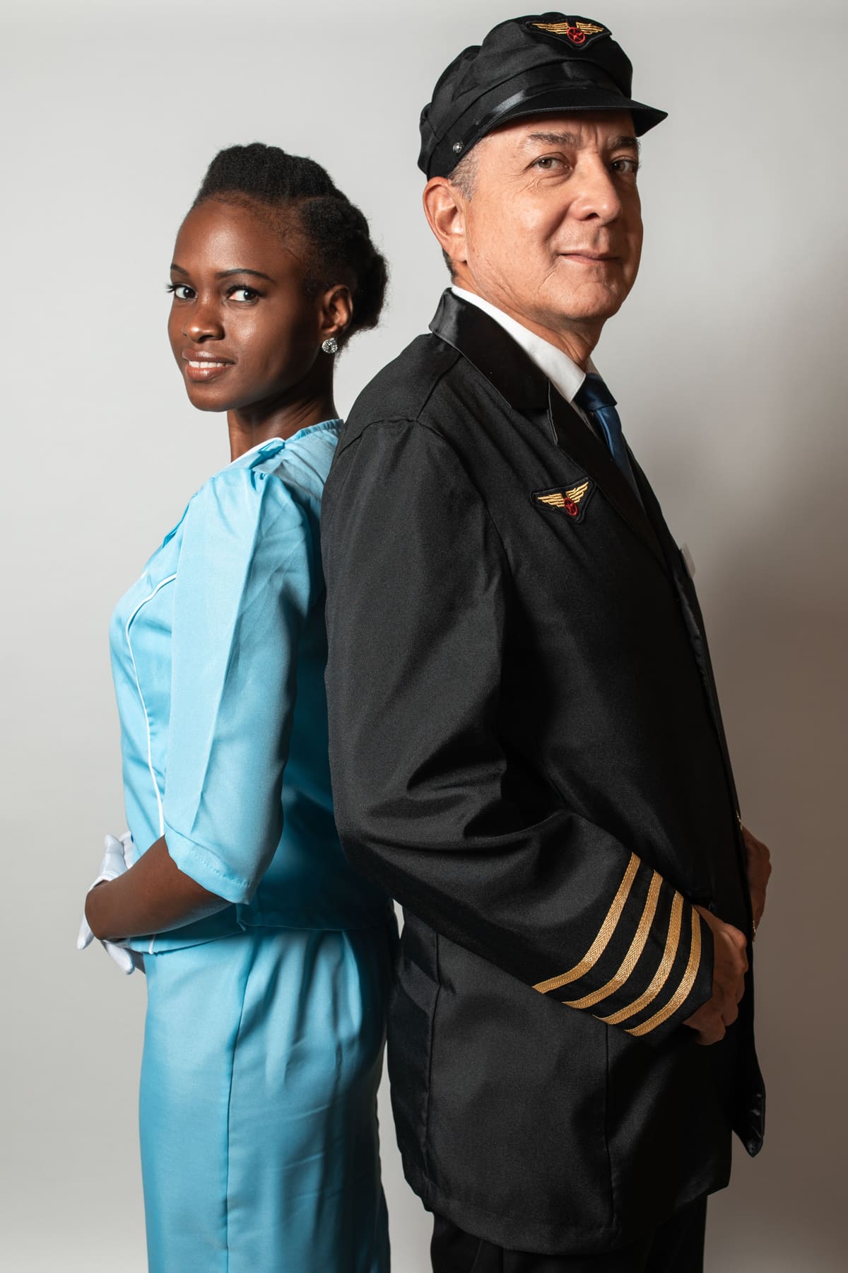 A pilot and a flight attendant standing together in matching airline uniforms